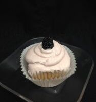 A vanilla cupcake with blackberry filling, topped with blackberry cream cheese and finished with a blackberry candy piece. Blackberry
