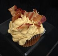 A brown sugar bacon cupcake topped with brown sugar cream cheese and finished with bacon pieces. Brown Sugar Bacon