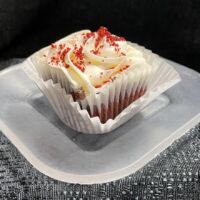 Red velvet cupcake with cream cheese frosting topped with red velvet crumbles. Red Velvet