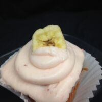 A strawberry cupcake, filled with banana pudding, topped with strawberry cream cheese and finished with a banana chip. Straw-Nana