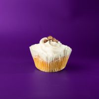 A vanilla cupcake with mini chocolate chips filled with a cookie dough filling, topped with vanilla buttercream and finished off with three cookie dough candy pieces. Cookie Dough cupcake