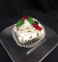 A chocolate cupcake with an Oreo pudding filing, topped with vanilla buttercream and finished with Oreo crumbs and a gummy worm. Dirt