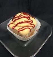 A vanilla cupcake with grape jelly filling, topped with peanut butter buttercream and a grape jelly drizzle. PBJ