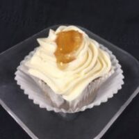 A spice cupcake filled with apple pie filling, topped with cream cheese icing, and finished with a dollop of apple pie filling. Apple Spice