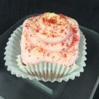 A strawberry cupcake with lemon filling, topped with strawberry cream cheese and finished with a dusting of lemon heads and dried strawberries. Strawberry Lemonade