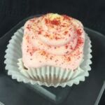 A strawberry cupcake with lemon filling, topped with strawberry cream cheese and finished with a dusting of lemon heads and dried strawberries. Strawberry Lemonade