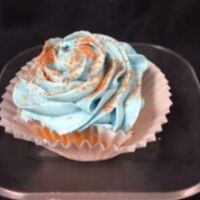 An orange cupcake, topped with blue raspberry cream cheese and finished with orange sanding sugar. Orange Blue Raspberry