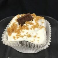 A chocolate cupcake filled with a marshmallow graham cracker mixture, topped with marshmallow buttercream and finished with a 1/4 Hershey's chocolate piece and graham cracker crumbs. S'Mores