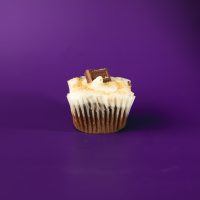 A chocolate cupcake filled with a marshmallow graham cracker mixture, topped with marshmallow buttercream and finished with a 1/4 Hershey's chocolate piece and graham cracker crumbs. S'Mores cupcake