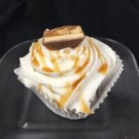 A chocolate cupcake with peanut butter chips, topped with vanilla buttercream and finished with a piece of a Snickers candy bar. Snickers