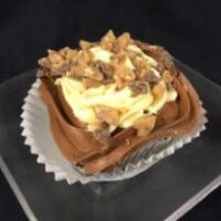 A chocolate cupcake filled with a sweet milk and heath bit mixture, topped with chocolate and caramel butter cream in a box style pattern then finished with heath candy bits. Toffee