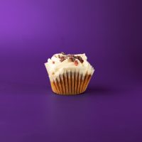 A cranberry almond white chocolate poundcake cupcake, iced in cream cheese icing and topped with frosted cranberries. Frosted Cranberry cupcake