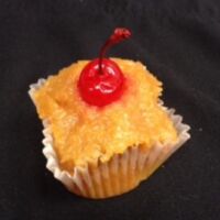 Pineapple cupcake topped and filled with pineapple upside down cake topping and finished with a cherry. Pineapple Upside Down
