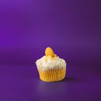 A banana cupcake filled with banana pudding, iced with vanilla buttercream and topped with a dollop of banana pudding and a Nilla Wafer. Banana Pudding cupcake