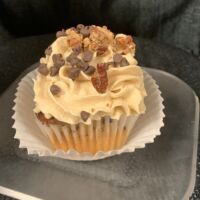 Butter pecan cupcake with chocolate and pecans inside and on top with pecan pie filling and brown sugar cream cheese icing. Derby Pie