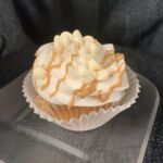 Vanilla cupcake filled with white peanut butter ganache, iced with vanilla buttercream and topped with white morsels and peanut butter drizzle. White Chocolate Peanut Butter