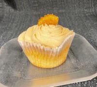 A banana cupcake with banana filling and brown sugar cream cheese icing, with a candied banana piece on top. Brown Sugar Banana