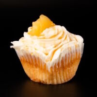 A caramel cupcake with an apple pie filling, cream cheese icing, and topped with drizzle of caramel and apple. Caramel Apple Pie